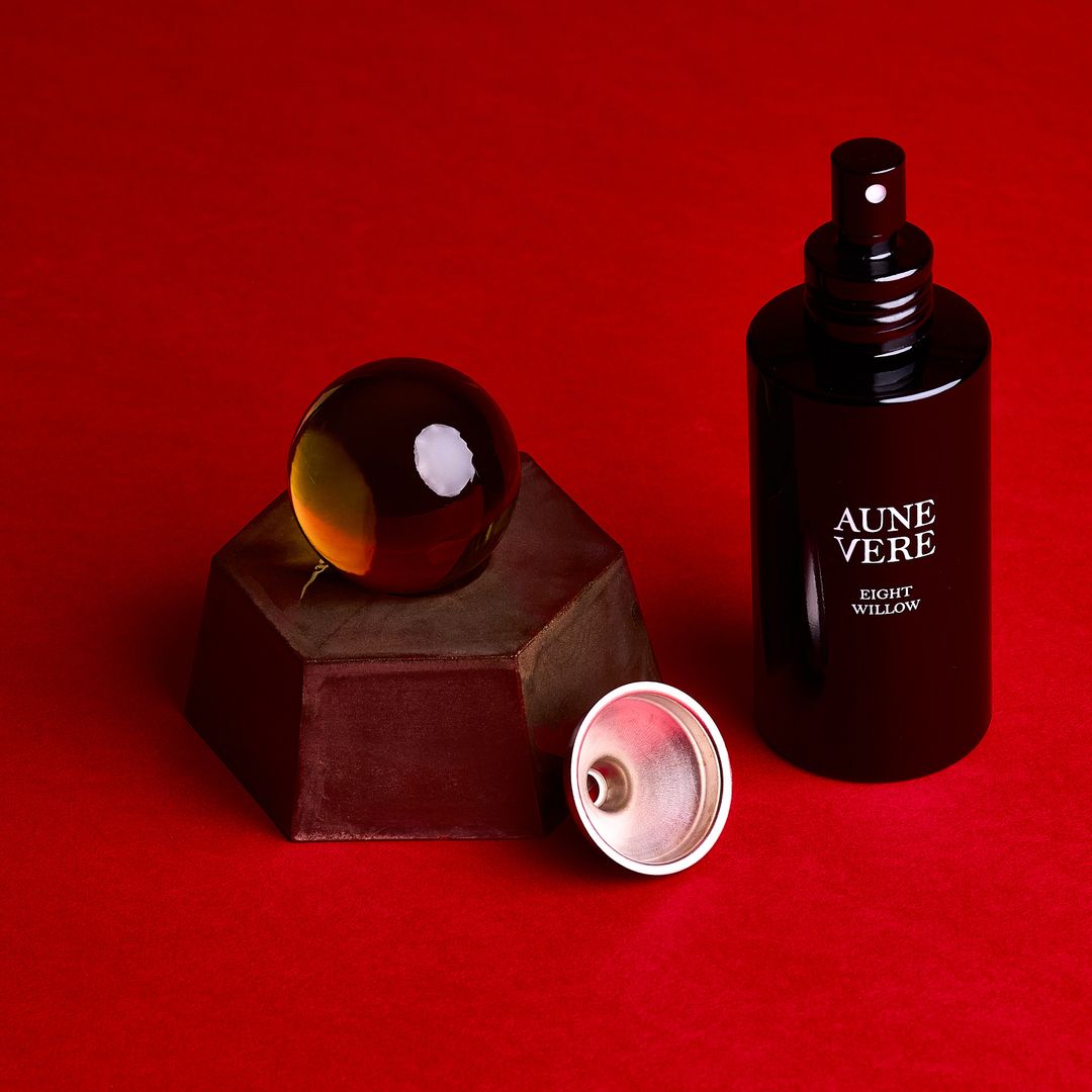 Eight Willow ceramic vessel with its 100 ml bottle and a silver funnel, assembled on alder red paper.