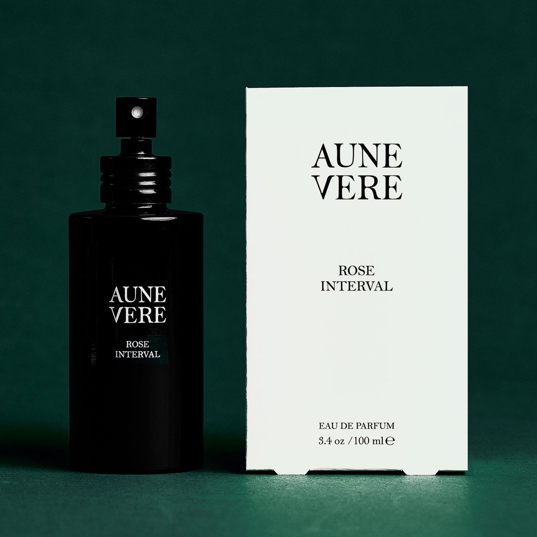 Rose Interval 100 ml bottle beside its carton, on green paper.
