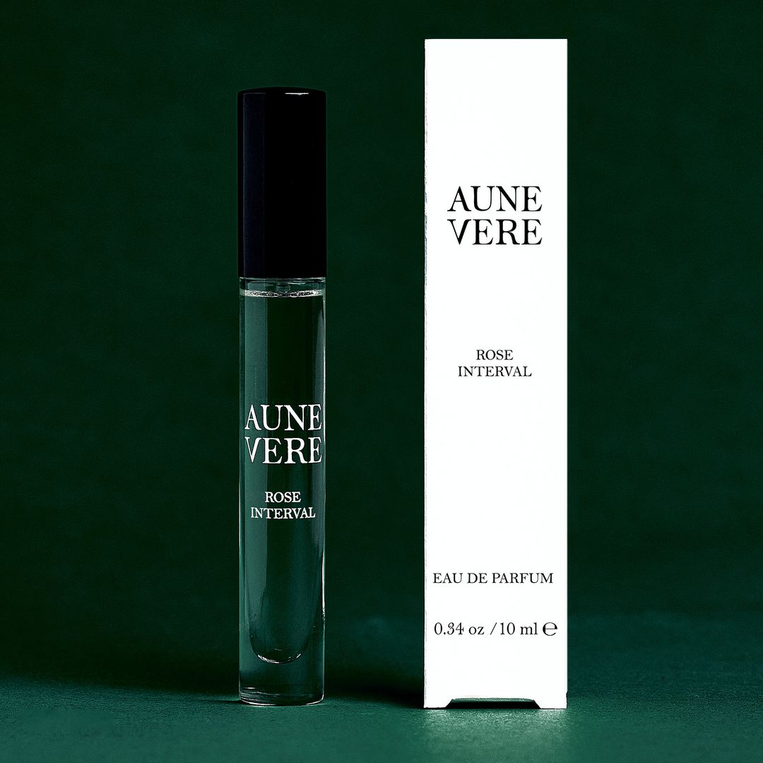 Rose Interval 10 ml bottle beside its carton, on green paper.